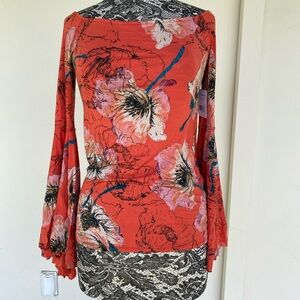Free people top in orange with multi color floral design. Size M